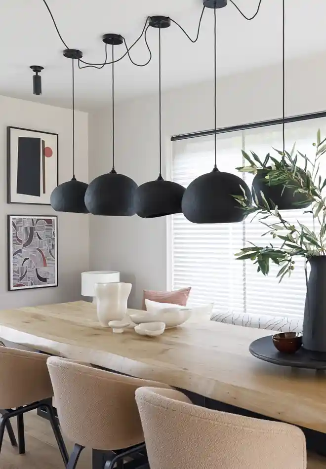 Woning met nieuwe raamdecoratie in Soest, tafel met stoelen, lampen en schilderijen